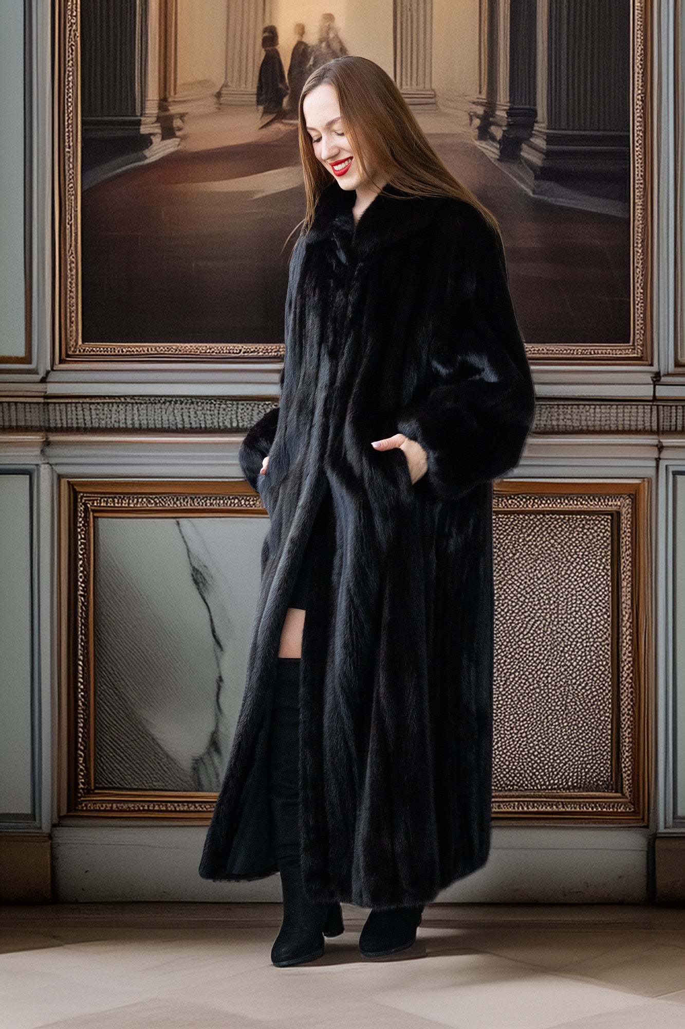 Woman wearing a long black coat standing in an elegant interior setting with framed pictures on the wall.