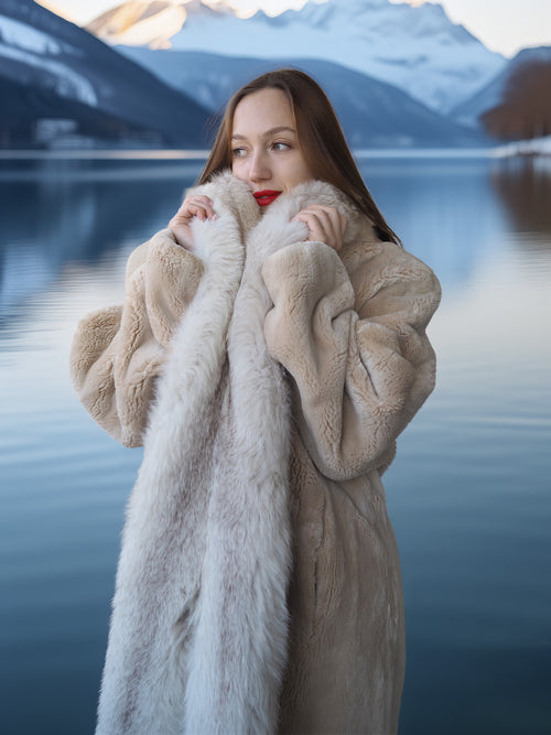 Woman wearing a fur coat with a mountainous landscape in the background