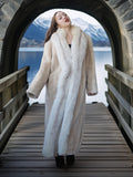 Woman in a fur coat standing on a wooden bridge with a scenic background