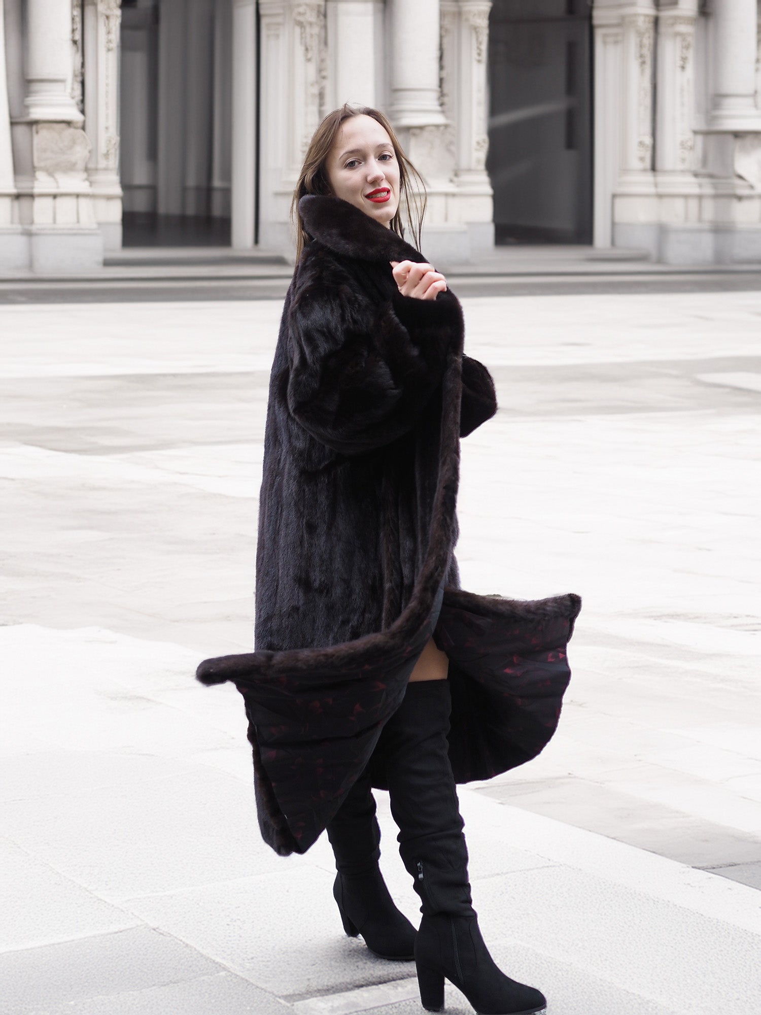 Black mink fur coat with a flowing silhouette, styled with boots for a fashionable and cozy winter outerwear look.