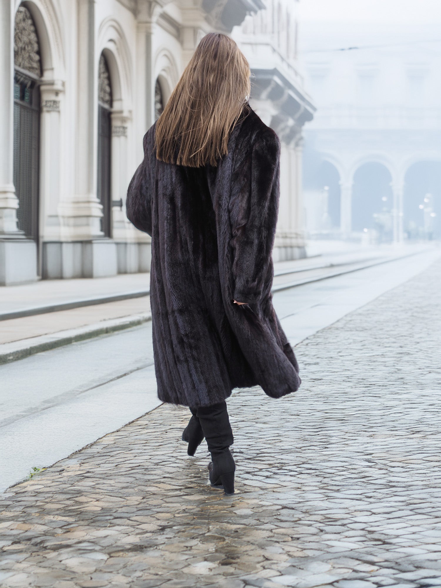 Back view of a black mink fur coat in motion, revealing its voluminous and luxurious design for winter fashion.