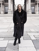 Elegant black mink fur coat with a structured collar and flowing hem, styled for sophisticated winter fashion.