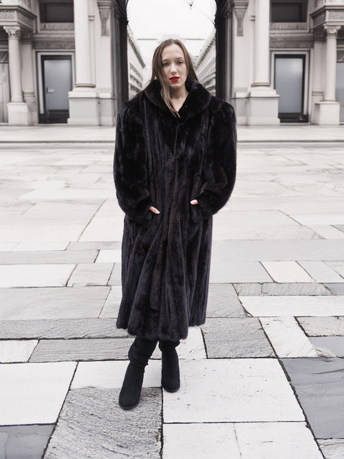 Elegant black mink fur coat with a structured collar and flowing hem, styled for sophisticated winter fashion.
