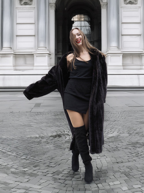 Chic black mink fur coat worn open over a black outfit, combining luxury fur fashion with modern street style.