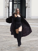 Model twirling in a black mink fur coat, revealing the patterned inner lining and luxurious movement of the coat.