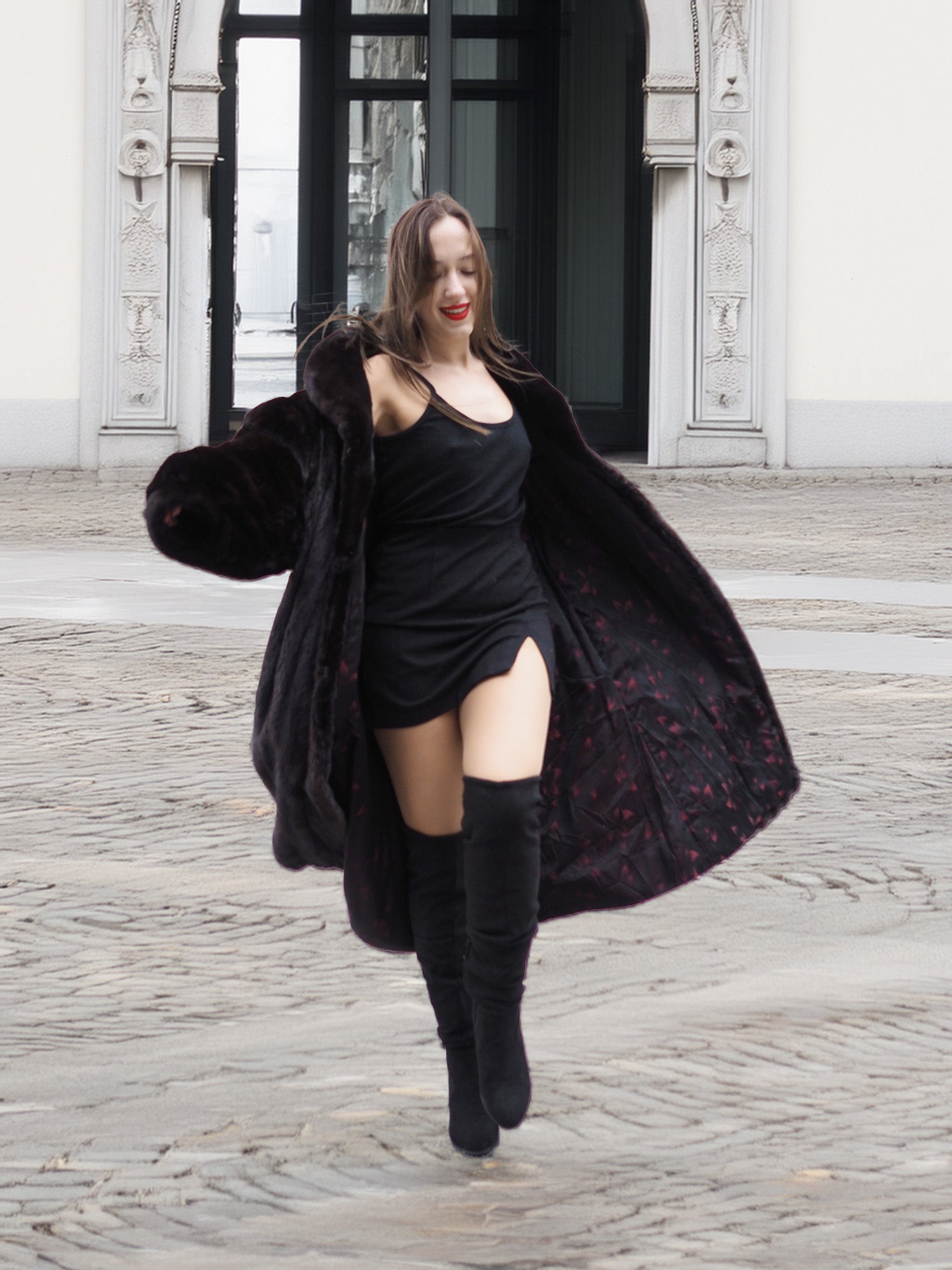 Model twirling in a black mink fur coat, revealing the patterned inner lining and luxurious movement of the coat.