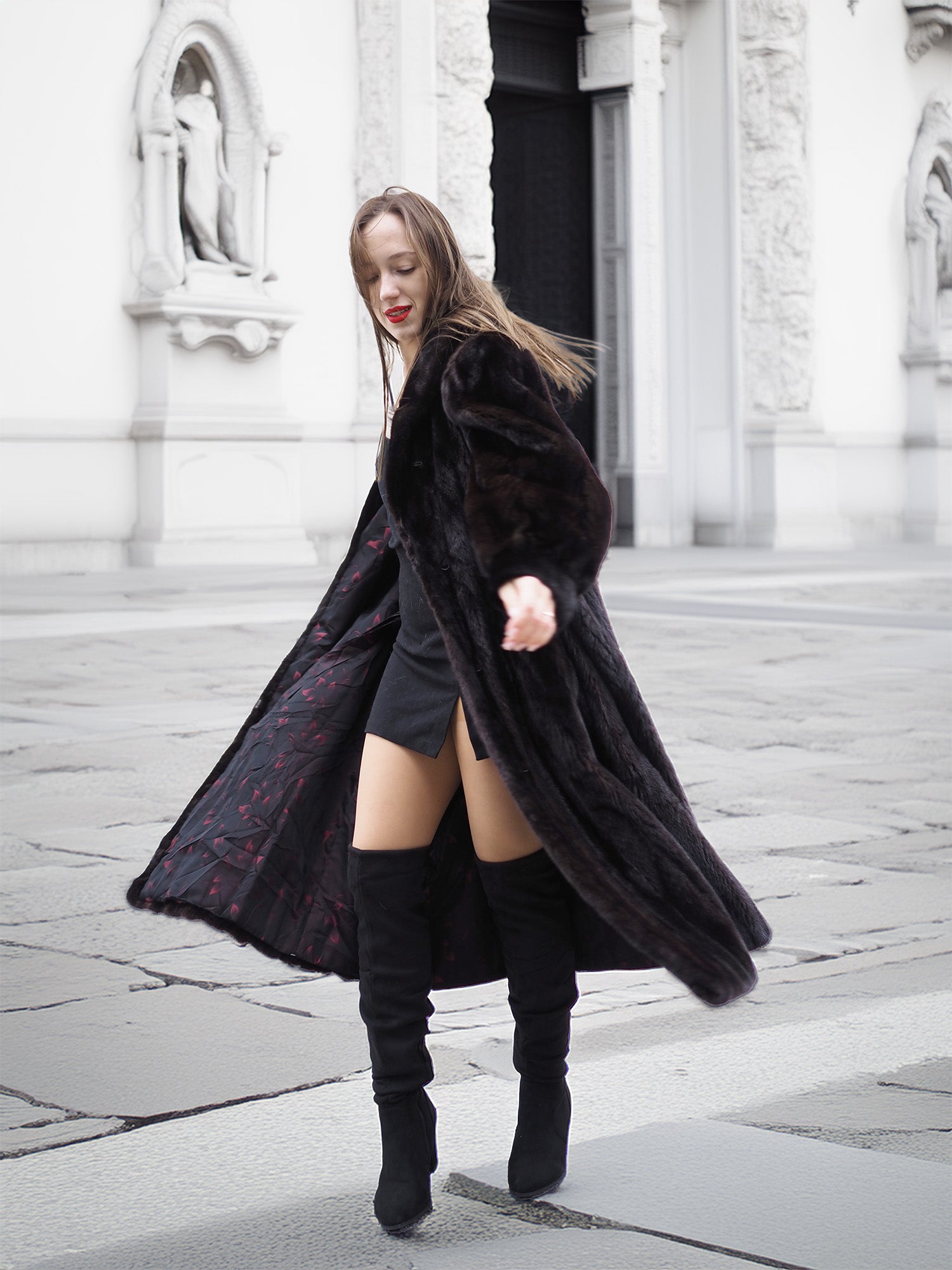Black mink fur coat opened to show its detailed lining, styled with a black outfit for a fashionable winter look.