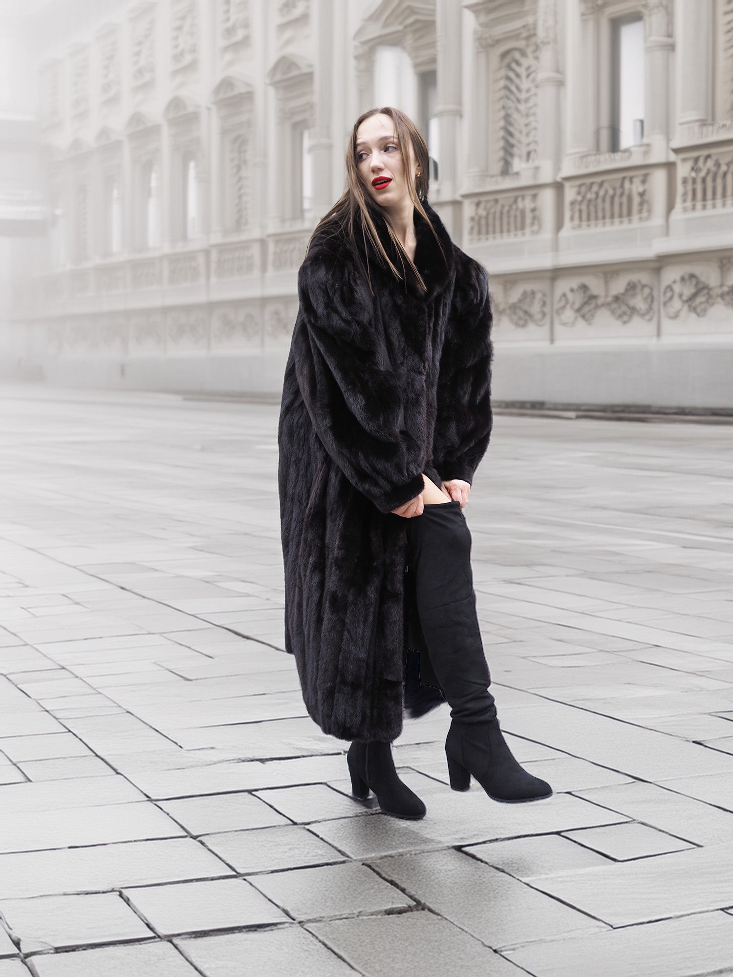 Model in a black mink fur coat walking on a foggy street, highlighting the coat’s warmth and luxurious appeal.