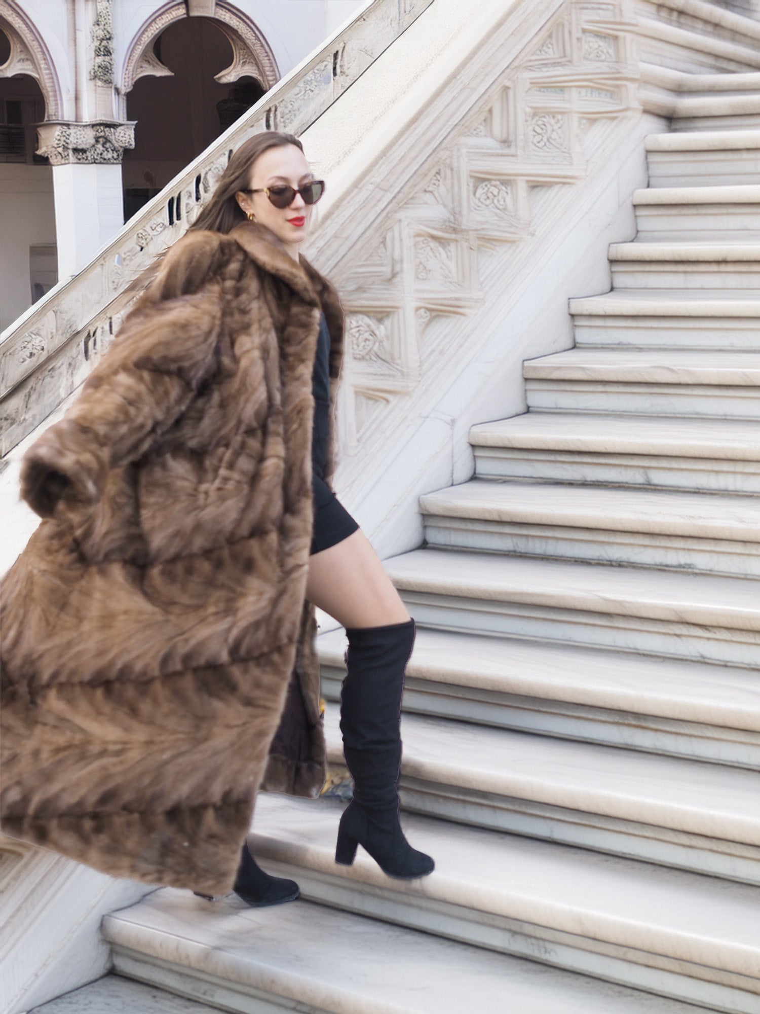 Espresso Mink Long Coat - Regal Swing styled on marble stairs, paired with black mini dress and boots for luxury outerwear appeal.