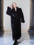 Woman wearing a black fur coat in an elegant interior setting