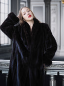 Woman wearing a dark fur coat in an elegant interior setting