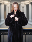 Woman wearing a black fur coat in an elegant interior setting