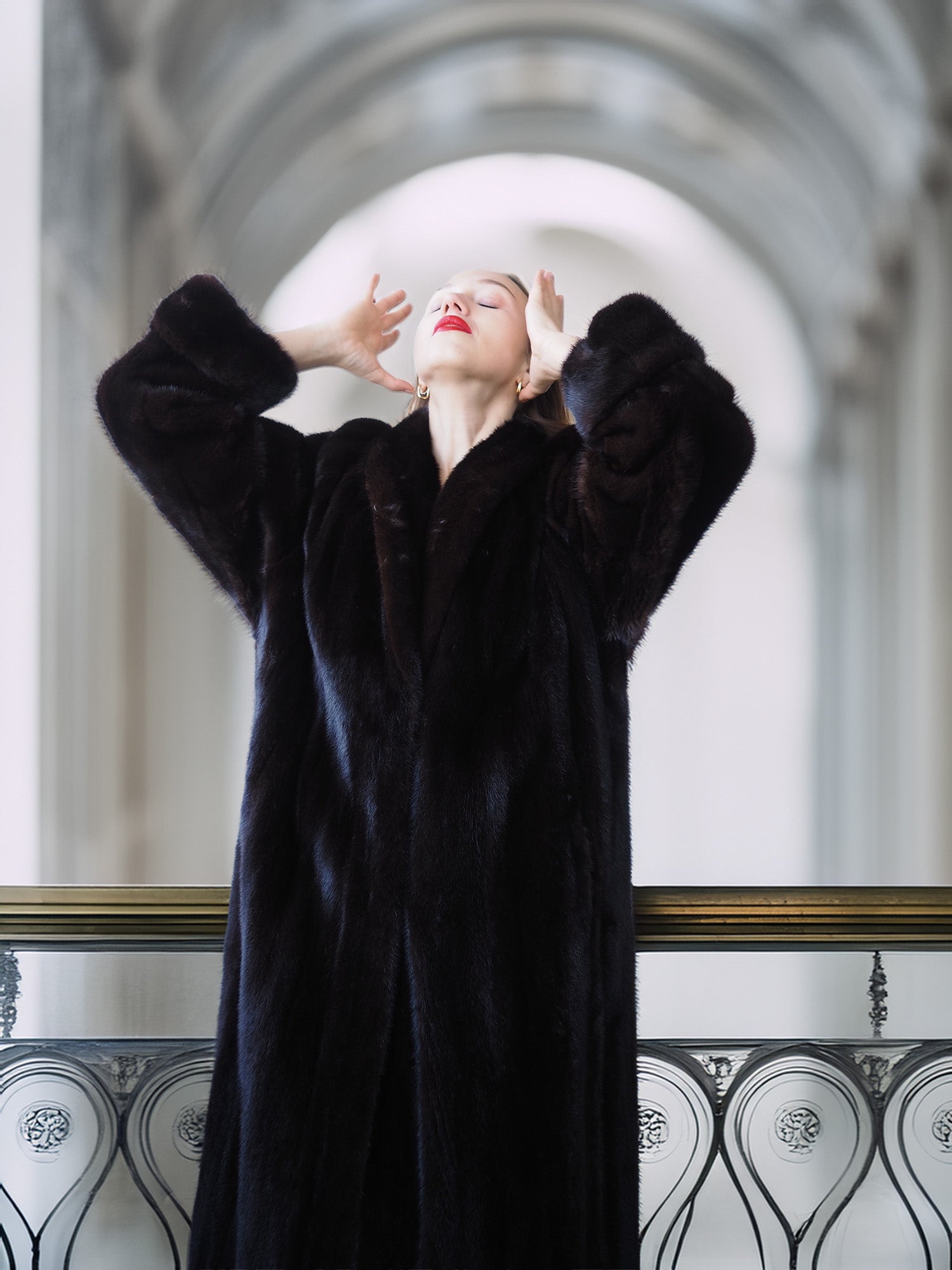 Woman wearing a black fur coat in an elegant interior setting