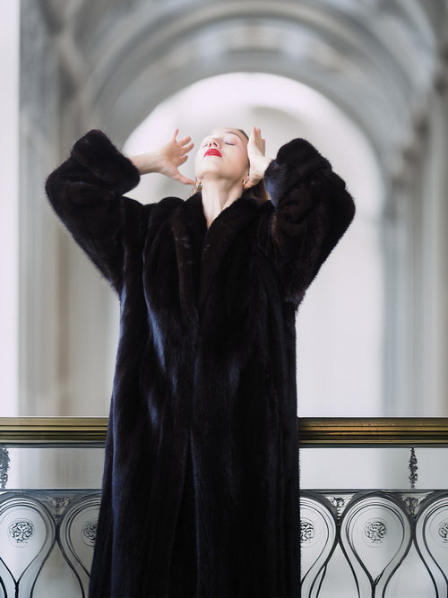 Woman wearing a black fur coat in an elegant interior setting