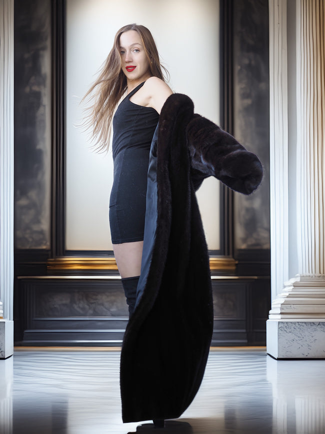 Woman holding a black coat in an elegant interior setting