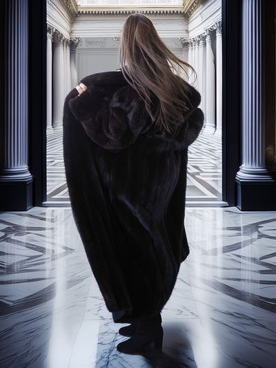Person wearing a dark coat in a grand hallway with columns