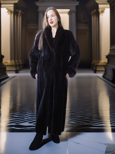 Woman wearing a long black coat in an elegant interior setting