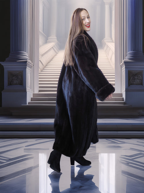 Woman in a long black coat standing in a classical architectural setting