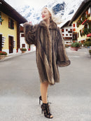a woman in a fur coat standing on a street