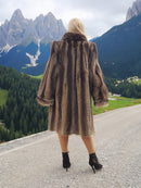 a woman in a fur coat standing on a road