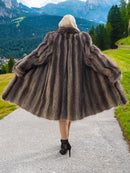 a woman in a fur coat walking down a path
