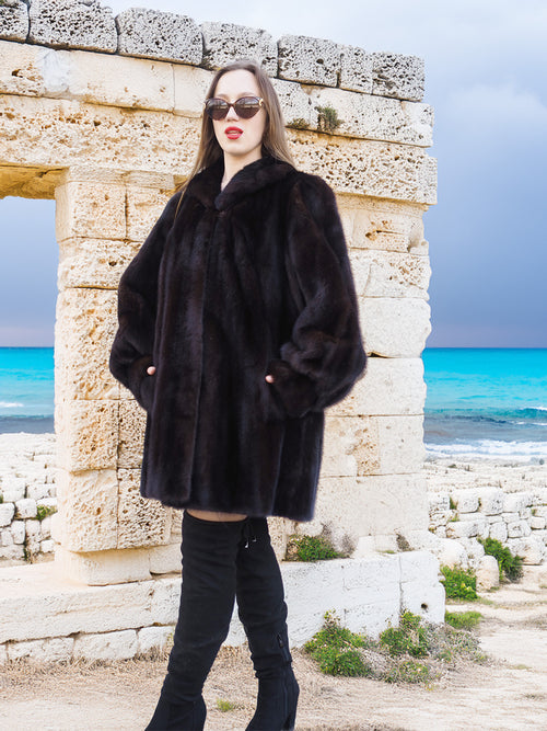 Riviera Noir Black Mink Swing Coat styled among ancient ruins. A luxurious and timeless mink fur coat for winter elegance.