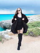 Riviera Noir Black Mink Swing Coat open over a black mini dress. Stylish and warm mink fur coat for luxury winter fashion.