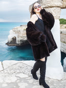 Black Mink Swing Coat - Riviera Noir styled with a black mini dress by the sea. Real mink fur coat for elegant winter fashion.