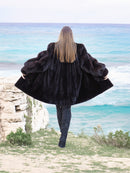 Black Mink Swing Coat - Riviera Noir styled in front of colorful shutters. Elegant and warm fur outerwear for winter fashion.