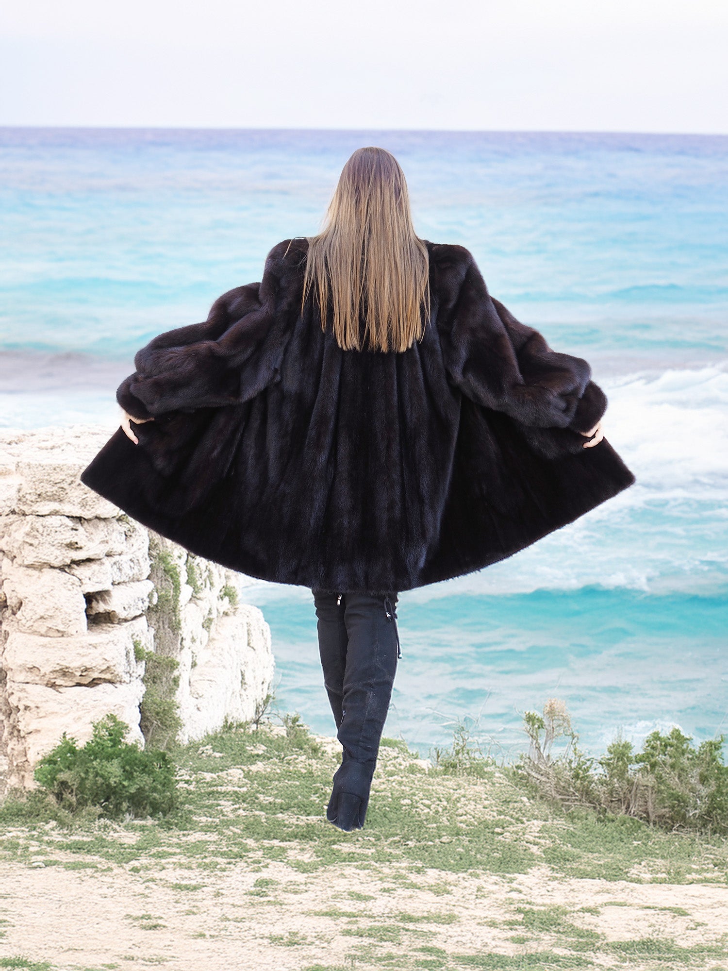 Black Mink Swing Coat - Riviera Noir styled in front of colorful shutters. Elegant and warm fur outerwear for winter fashion.