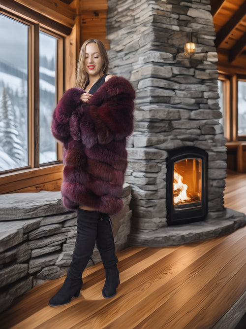 Woman in a fur coat standing in front of a stone fireplace with a snowy landscape outside.