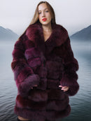 Woman wearing a fur coat with a mountainous landscape in the background