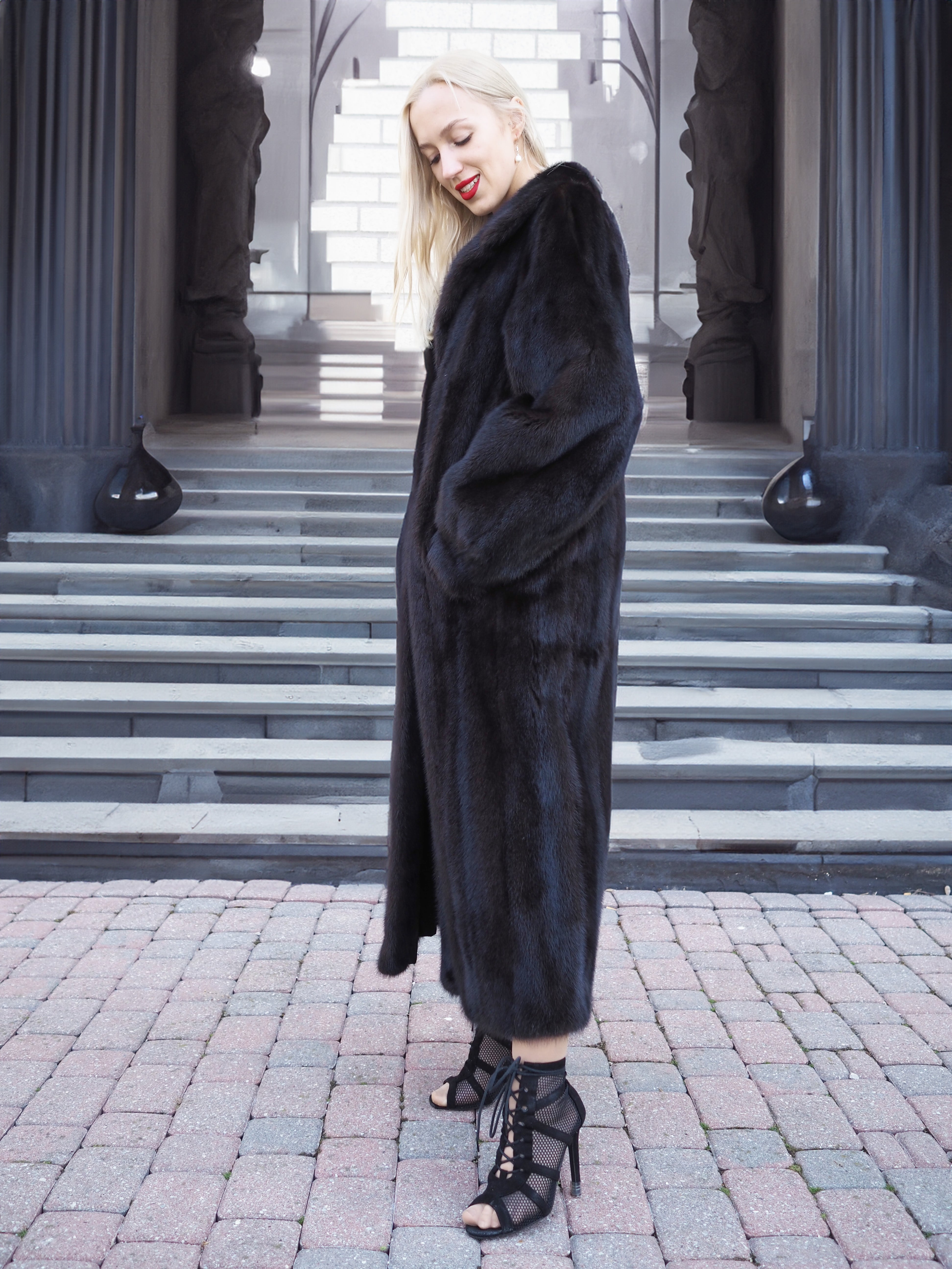 Elegant black mink fur coat on woman, full-length winter fashion accessory.