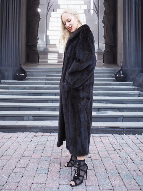 Elegant black mink fur coat on woman, full-length winter fashion accessory.