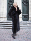 Elegant black mink fur coat, woman standing on stairs against ornate building entrance