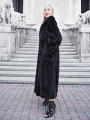 Luxurious black mink fur coat, elegant woman posing on stairs, high-fashion attire
