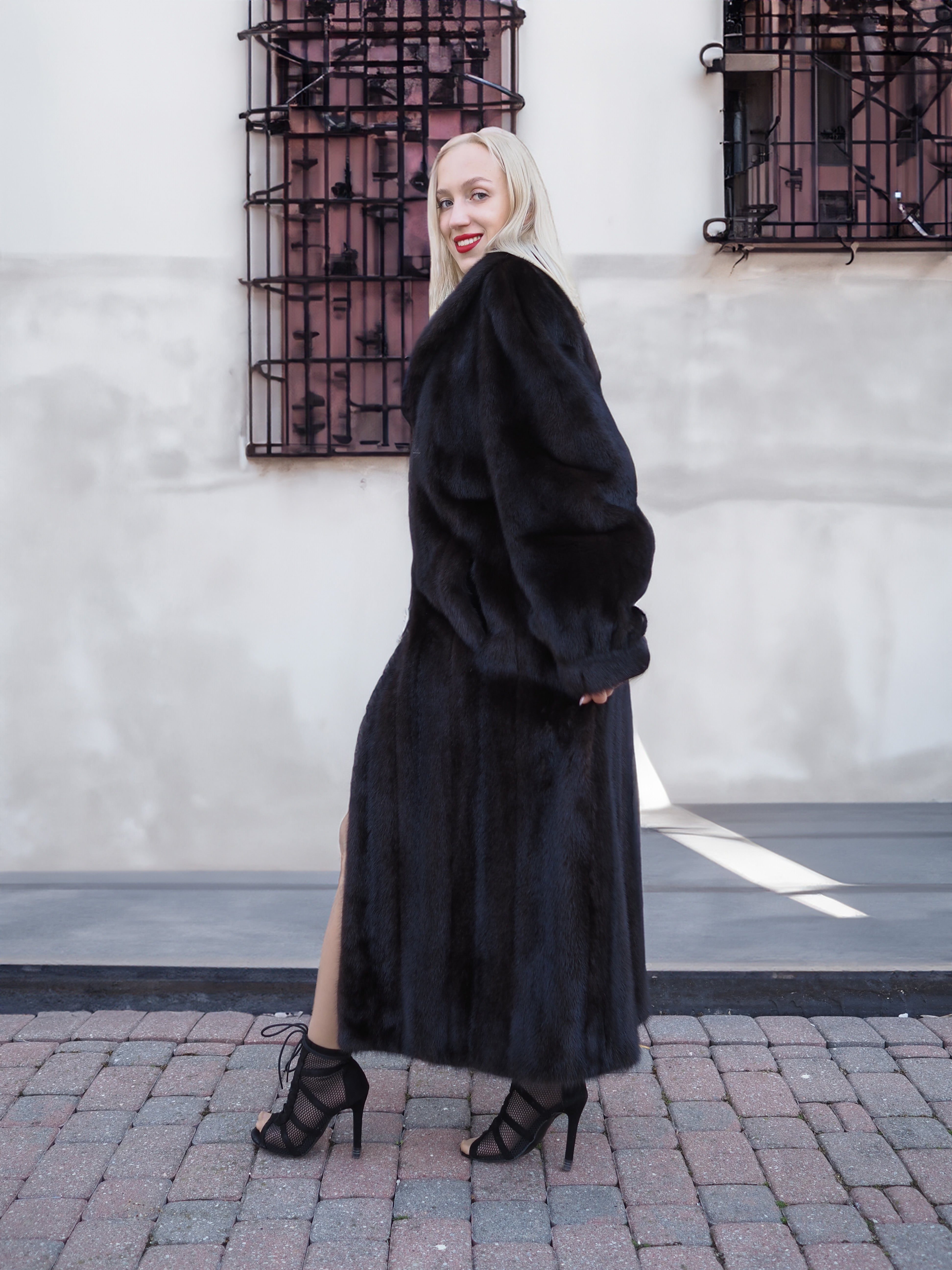Chic black mink fur coat, classic and elegant silhouette, complemented by fashionable heels for a sophisticated urban look.