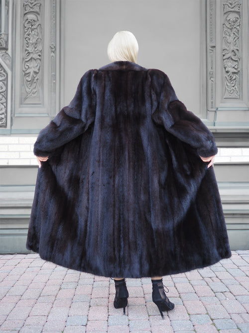 Luxurious black mink fur coat with elegant design and tailored fit, showcased against an ornate architectural background.