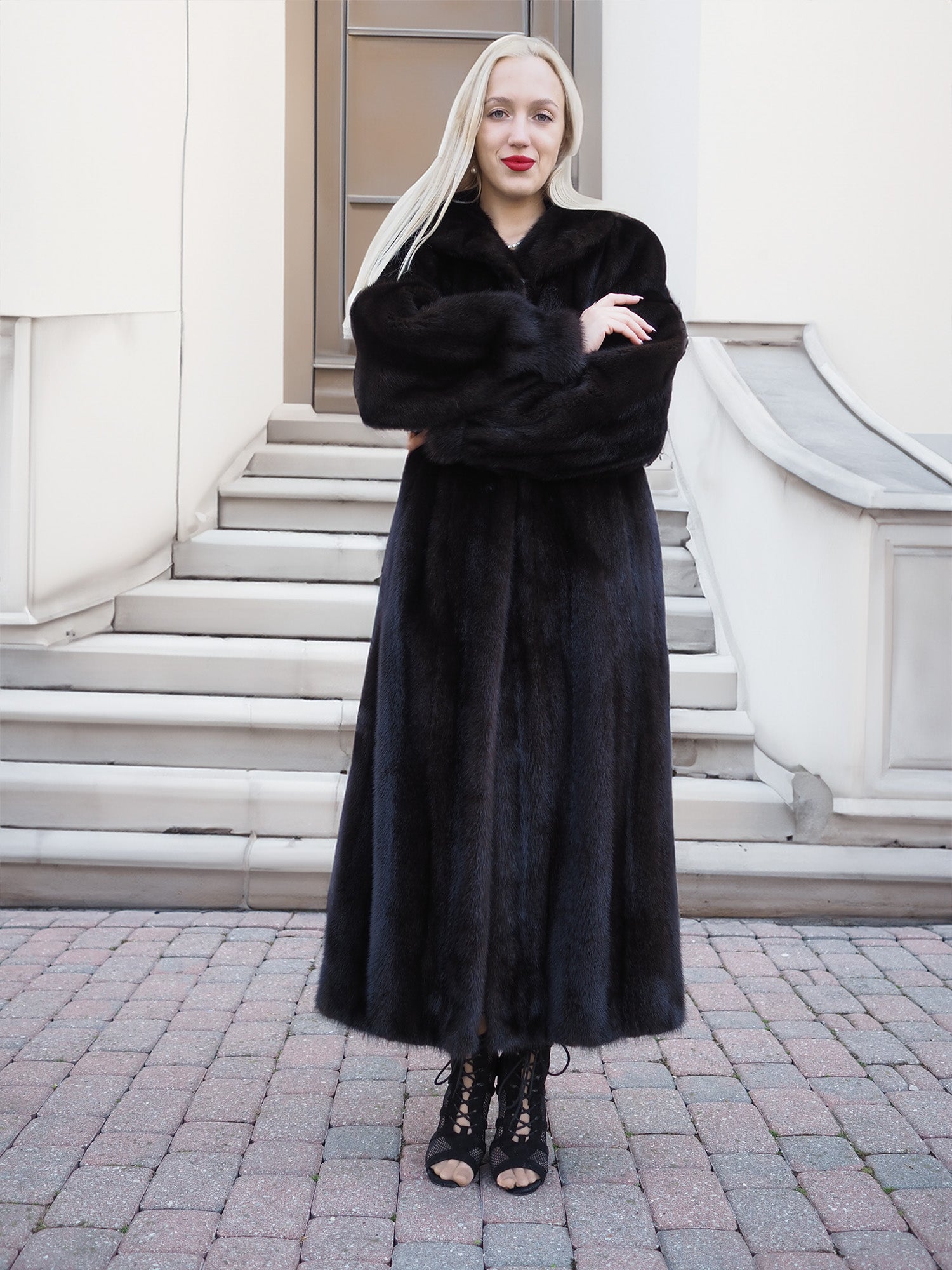 Elegant black mink fur coat worn by stylish woman on urban steps