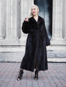 Elegant black mink fur coat on model posing outdoors in front of columns