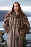Woman wearing a fur coat standing outdoors with a scenic background