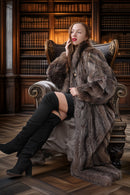 Woman in a fur coat sitting on an ornate chair in a library setting