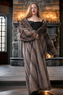 Woman wearing a fur coat and dress in a room with stone walls and candles.