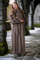 Woman wearing a fur coat standing in a stone archway.