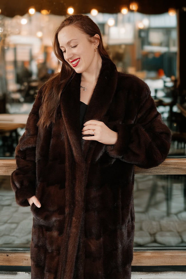 Woman wearing a brown fur coat in an indoor setting with blurred background