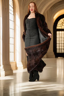 Woman holding a fur coat in an elegant interior setting