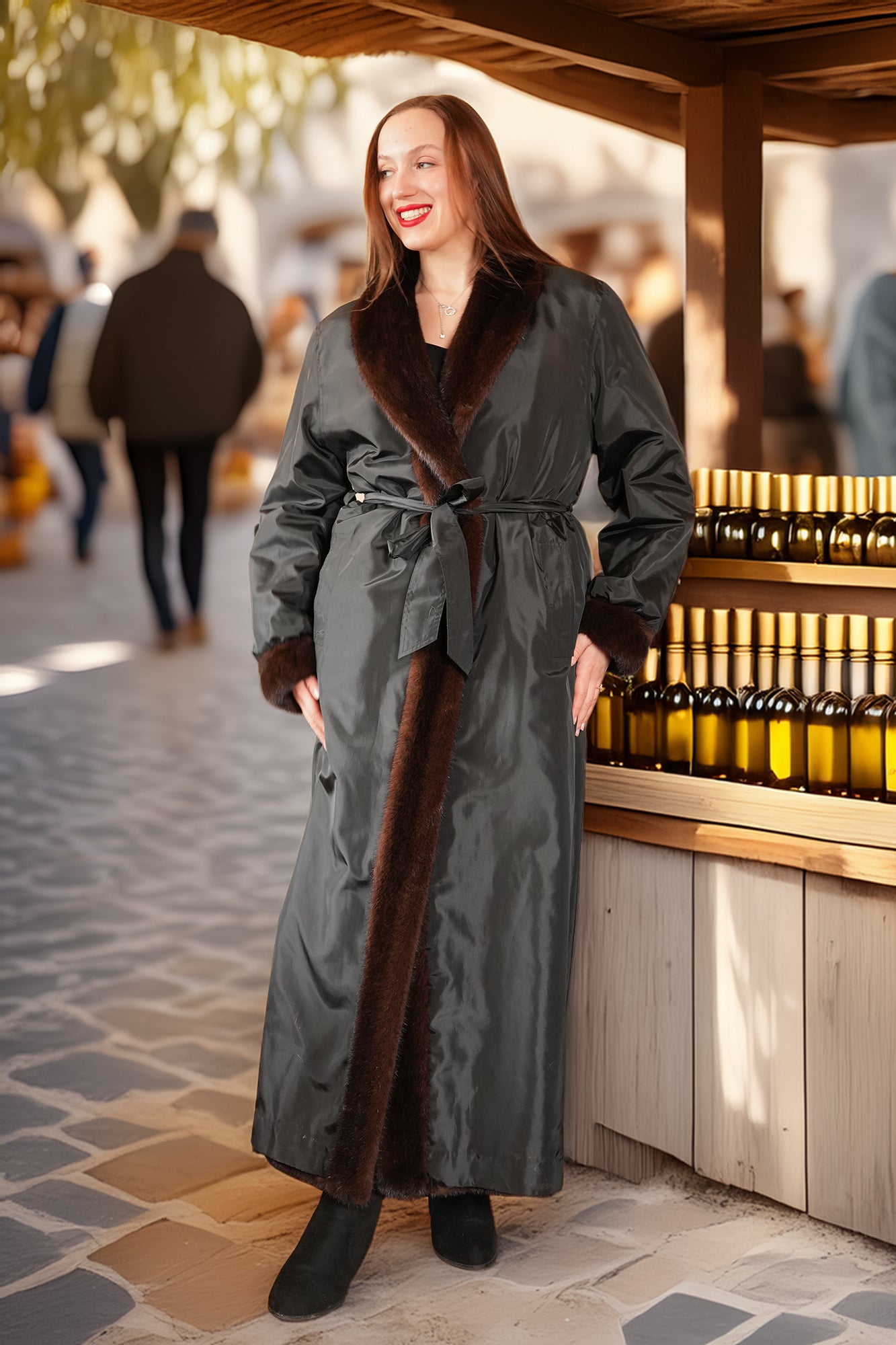 Woman in a long gray coat with fur trim standing in an outdoor setting.