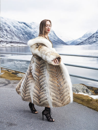 Coyote fur coat with white trim by lake