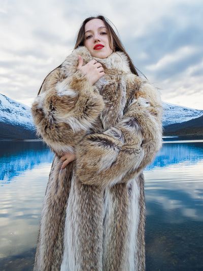 Authentic 50" Vintage Coyote Fur Coat with thick collar and rich texture, modeled in front of a snowy mountain lake backdrop.