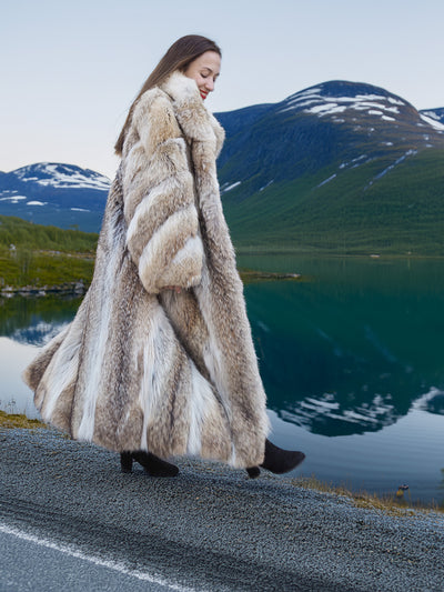 Vintage Coyote Fur Coat in Wild Luxury, worn beside a reflective lake with snow-capped peaks in the background.